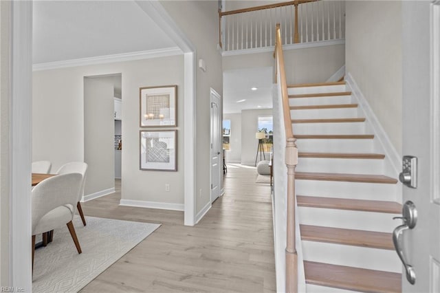 entrance foyer with light hardwood / wood-style floors and ornamental molding