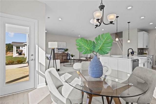 dining room featuring light hardwood / wood-style flooring, an inviting chandelier, and sink