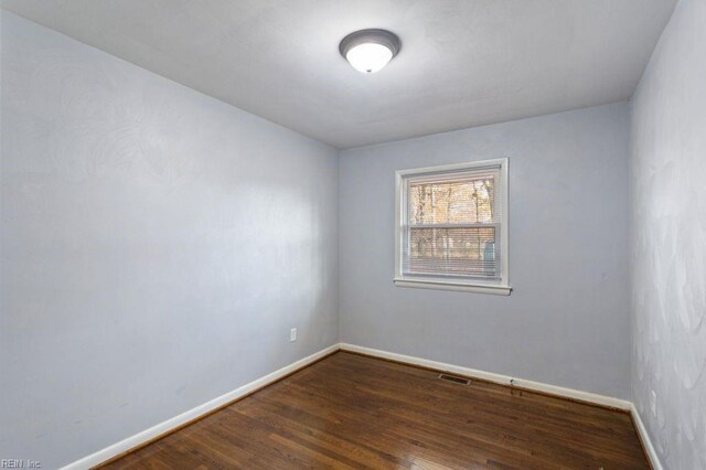 empty room with dark hardwood / wood-style flooring