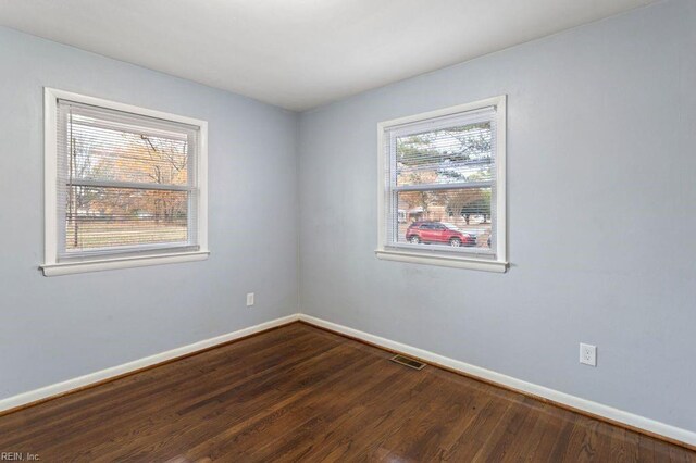 unfurnished room with dark wood-type flooring