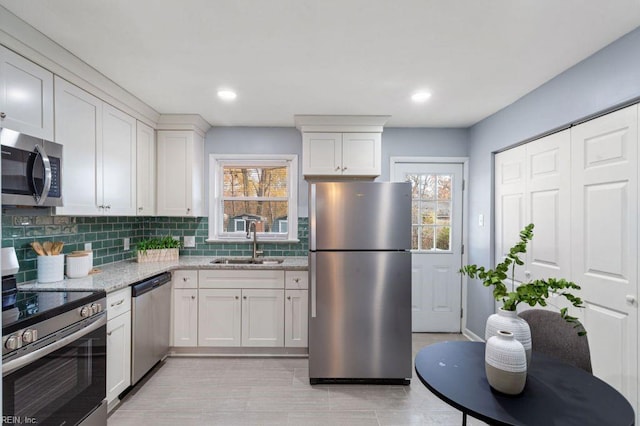 kitchen with white cabinets, light stone countertops, sink, and appliances with stainless steel finishes