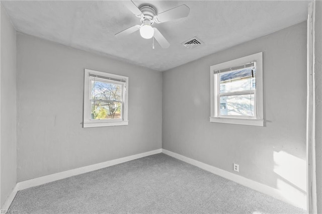 empty room featuring ceiling fan and carpet