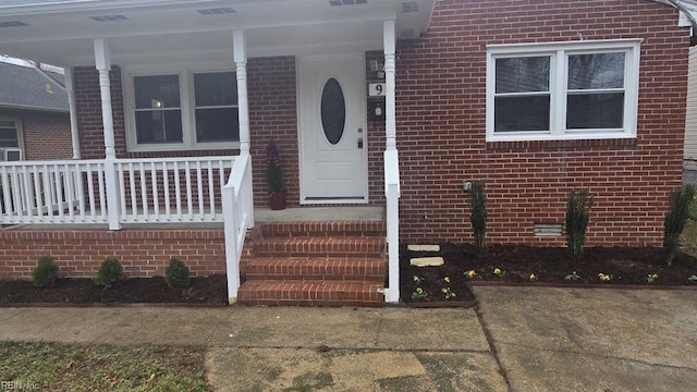 view of exterior entry with covered porch