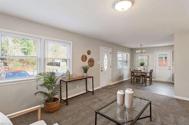 living room featuring an inviting chandelier and dark wood-type flooring