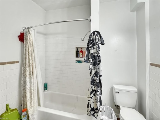 bathroom with shower / tub combo, toilet, and tile walls