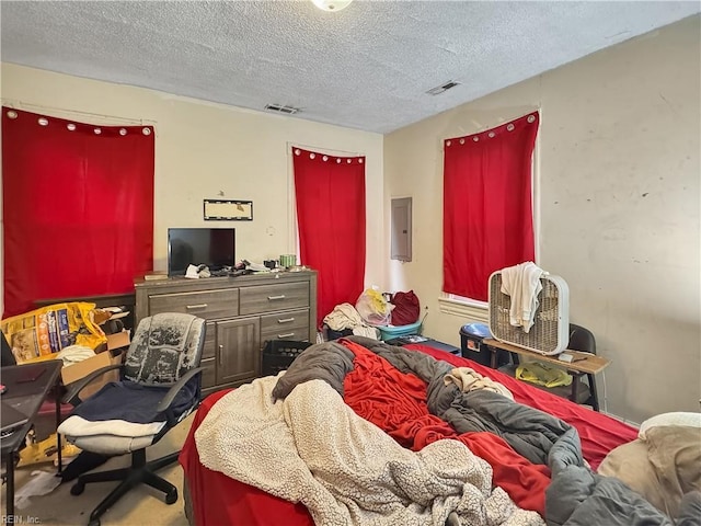 bedroom featuring a textured ceiling and electric panel