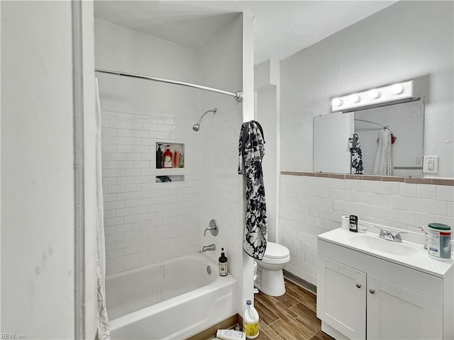 full bathroom featuring hardwood / wood-style floors, shower / bath combination with curtain, toilet, vanity, and tile walls