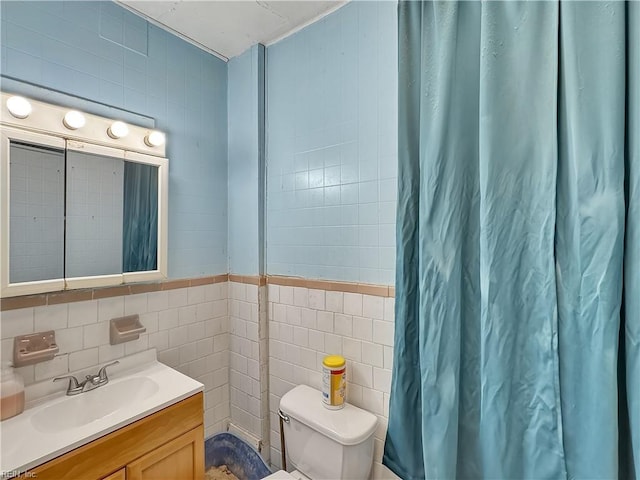 bathroom with vanity, tile walls, and toilet