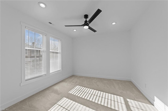 spare room with light colored carpet and ceiling fan