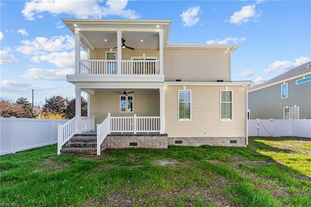 back of house featuring a lawn, ceiling fan, a balcony, and covered porch