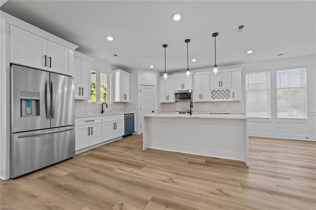 kitchen with white cabinetry, decorative light fixtures, and appliances with stainless steel finishes