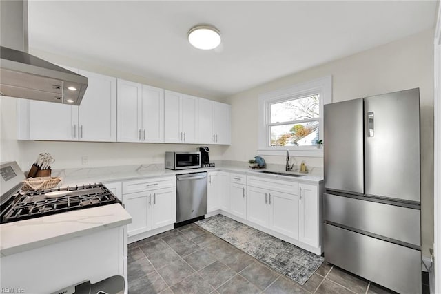 kitchen featuring white cabinets, sink, light stone countertops, appliances with stainless steel finishes, and island range hood