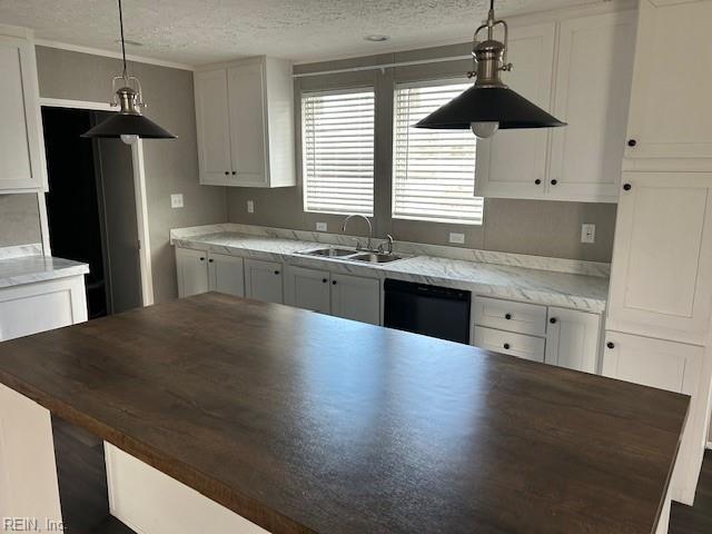 kitchen featuring white cabinets, black dishwasher, decorative light fixtures, and sink