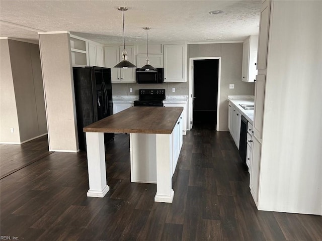 kitchen with wood counters, dark hardwood / wood-style flooring, pendant lighting, white cabinets, and black appliances