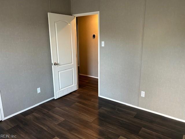 empty room with dark wood-type flooring