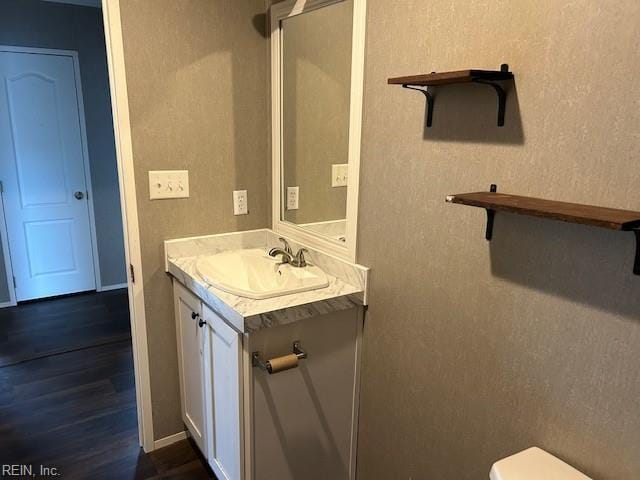 bathroom featuring vanity, hardwood / wood-style flooring, and toilet