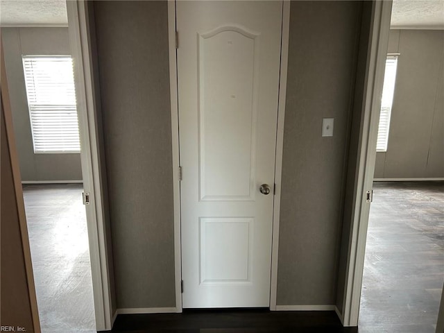 corridor with dark wood-type flooring and a textured ceiling