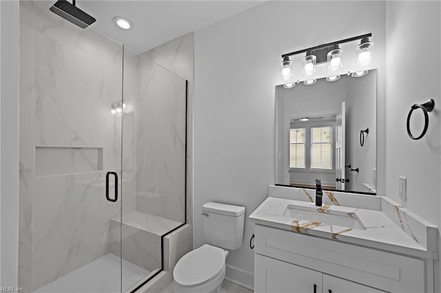 bathroom with vanity, a shower with shower door, and toilet