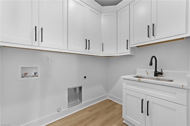 clothes washing area featuring electric dryer hookup, cabinets, sink, light hardwood / wood-style flooring, and washer hookup