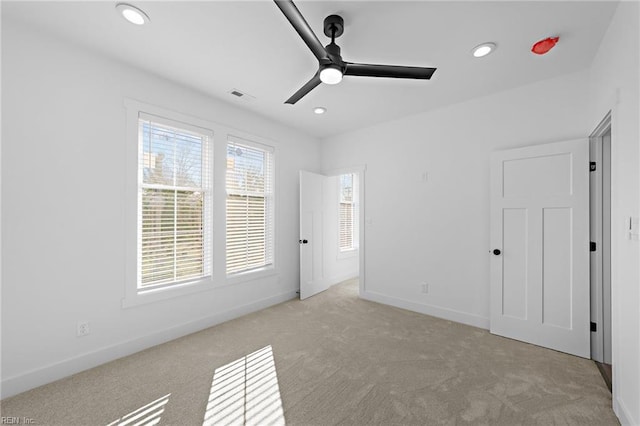 unfurnished bedroom with ceiling fan and light colored carpet