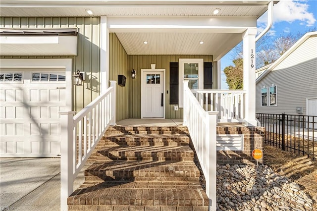 view of exterior entry with covered porch and a garage