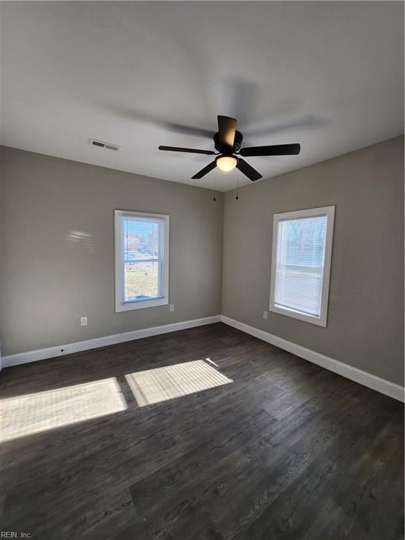 spare room featuring ceiling fan and dark wood-type flooring