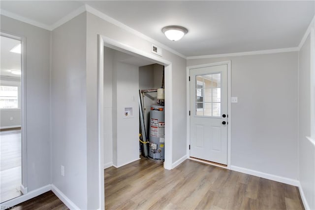 foyer with light wood-type flooring, gas water heater, and crown molding