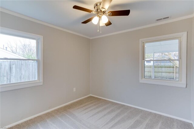 spare room featuring ceiling fan, carpet floors, ornamental molding, and a wealth of natural light