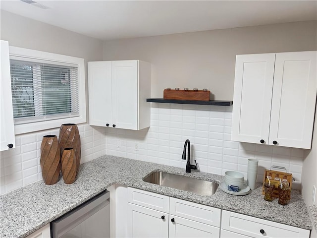 kitchen with sink, white cabinetry, backsplash, and dishwasher