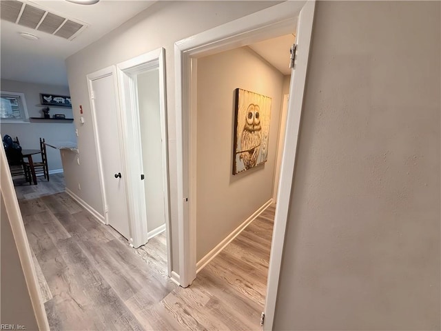 hallway featuring light hardwood / wood-style flooring and a barn door