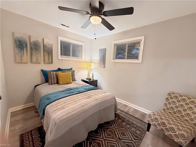 bedroom featuring ceiling fan, hardwood / wood-style floors, and electric panel