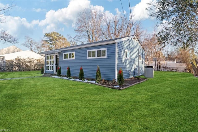 rear view of property with a yard and central air condition unit