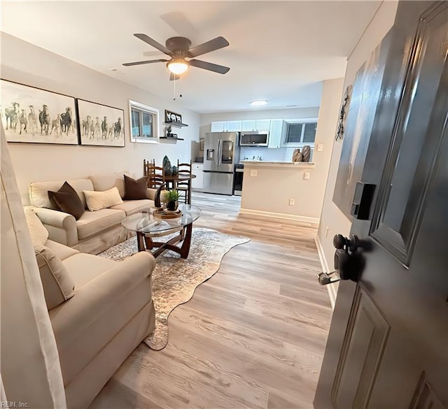 living room with ceiling fan and light hardwood / wood-style floors