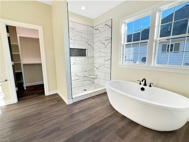 bathroom with hardwood / wood-style floors and shower with separate bathtub