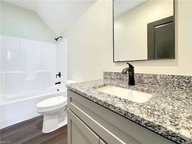 full bathroom with  shower combination, vanity, wood-type flooring, toilet, and lofted ceiling