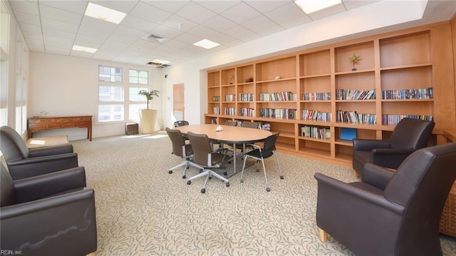 carpeted home office with a drop ceiling