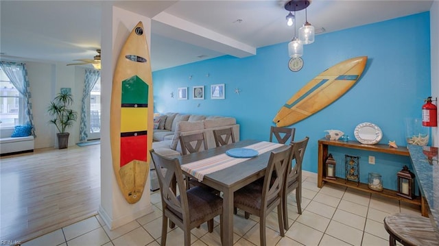 dining space with ceiling fan, beam ceiling, and light wood-type flooring