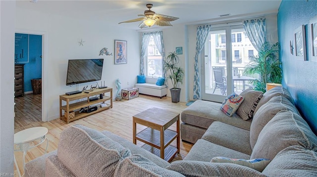 living room with ceiling fan, plenty of natural light, and light hardwood / wood-style floors