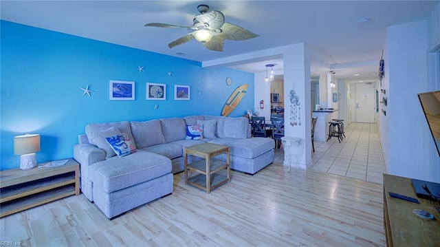 living room featuring light wood-type flooring and ceiling fan