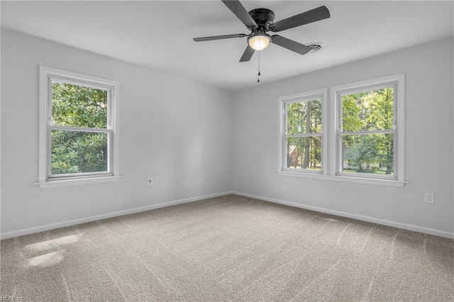 carpeted spare room featuring ceiling fan and a wealth of natural light