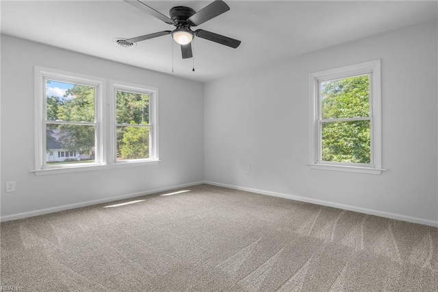 empty room featuring carpet flooring, ceiling fan, and plenty of natural light