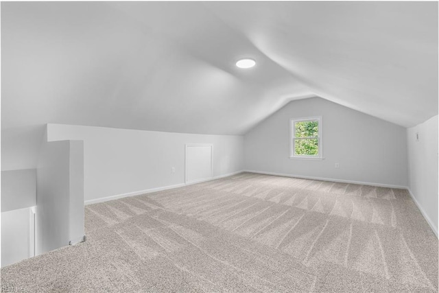 bonus room with light colored carpet and lofted ceiling