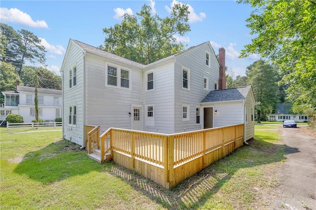 rear view of house with a yard and a deck