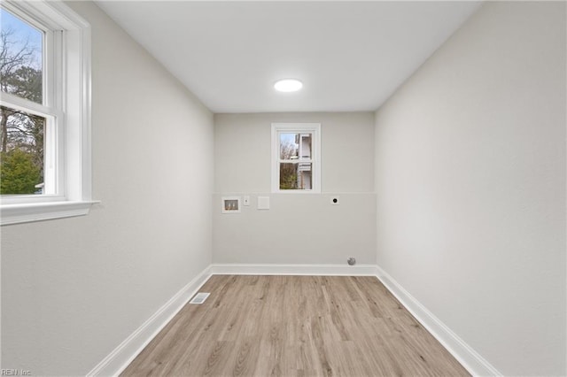 laundry room with hookup for an electric dryer, hookup for a washing machine, light hardwood / wood-style flooring, and a healthy amount of sunlight