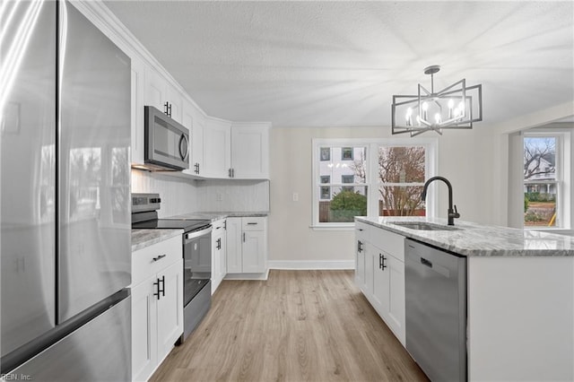 kitchen featuring plenty of natural light, white cabinets, and stainless steel appliances