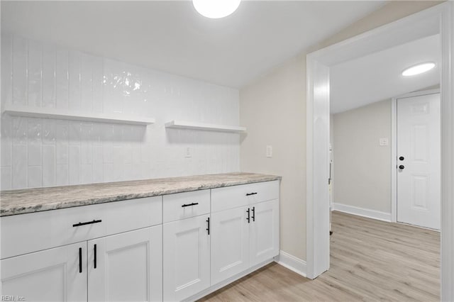 bar featuring light hardwood / wood-style floors and white cabinetry