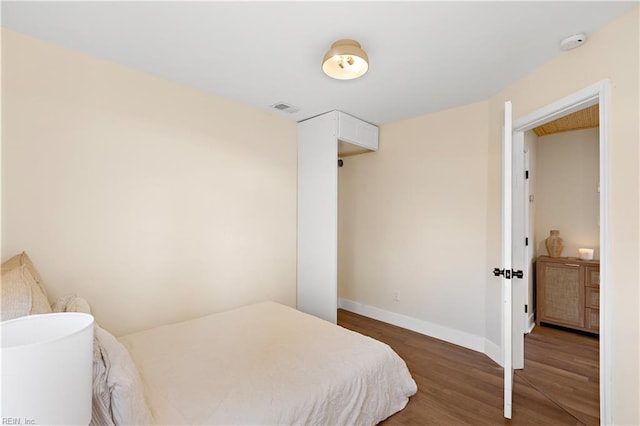 bedroom with dark wood-type flooring