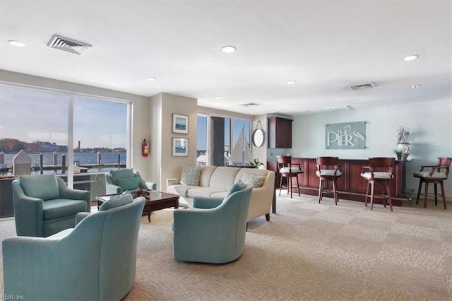 carpeted living room featuring bar area