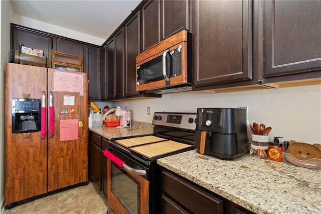 kitchen with light stone countertops, appliances with stainless steel finishes, and dark brown cabinetry