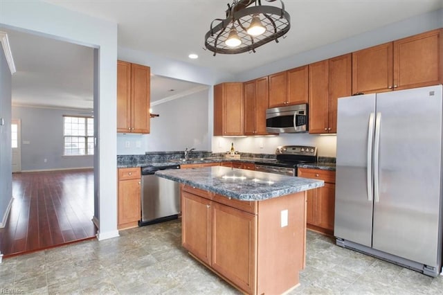 kitchen featuring a center island, light hardwood / wood-style flooring, decorative light fixtures, appliances with stainless steel finishes, and ornamental molding